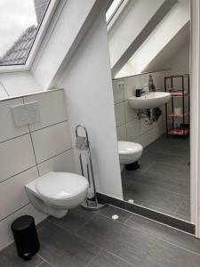 a bathroom with a toilet and a sink at Dach-Maisonette "Villa Karola" an der Therme in Bad Sulza