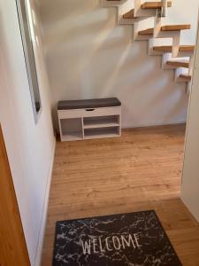 a hallway with a staircase with a rug and a welcome mat at Dach-Maisonette "Villa Karola" an der Therme in Bad Sulza