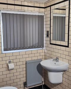 a bathroom with a sink and a toilet and a mirror at The Liverpool Pod Travel Hostel in Liverpool