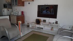 Una sala de estar con un televisor en la pared. en Casa das Gaivotas, en Itanhaém 6 fotos más