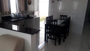 a kitchen with a table and chairs in a room at Casa das Gaivotas in Itanhaém