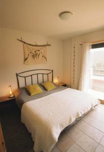 Sant Llorenç de la Muga的住宿－Hostal de l'Aigua，一间卧室配有一张大床和两张黄色枕头
