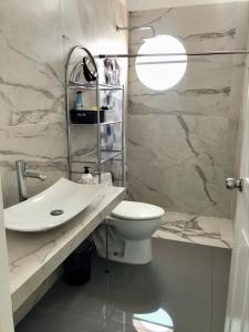 La salle de bains blanche est pourvue de toilettes et d'un lavabo. dans l'établissement Casa de Colima, à Colima