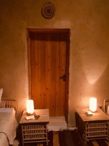 a room with two tables with candles in front of a door at Tanirt ecolodge in Siwa