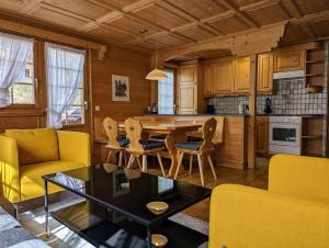 a kitchen with a dining room table and yellow chairs at Maisonette-Wohnung in Rueras bei Sedrun in Rueras