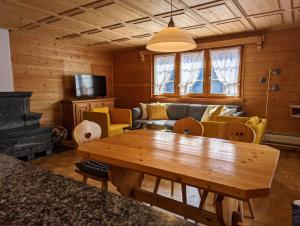 a living room with a wooden table and a couch at Maisonette-Wohnung in Rueras bei Sedrun in Rueras