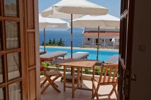 a patio with tables and umbrellas and a swimming pool at Lycia Hotel in Kaş