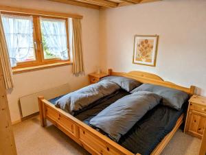 a bedroom with a wooden bed with two pillows at Maisonette-Wohnung in Rueras bei Sedrun in Rueras