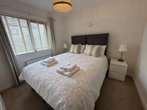 a bedroom with a bed with two towels on it at 1 Island View in Portrush
