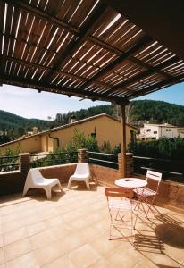 Sant Llorenç de la Muga的住宿－Hostal de l'Aigua，一个带桌椅的庭院和一个木制凉亭