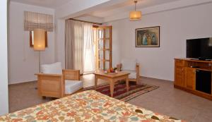 a hotel room with a bedroom with a bed and a tv at Lycia Hotel in Kaş