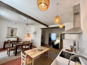 a kitchen and living room with a table and a dining room at La Maison de Lola in Carpentras +2 photos