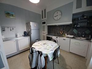 kuchnia ze stołem i zegarem na ścianie w obiekcie maison 4 à 6 personnes proche village w mieście Pélissanne +9 zdjęć
