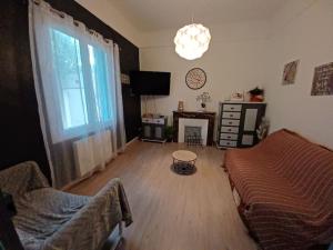 salon z kanapą, stołem i oknem w obiekcie maison 4 à 6 personnes proche village w mieście Pélissanne