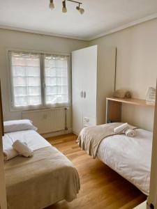 a bedroom with two beds and a window at BeraBera,Parking free,2WC,Terraza,Aire acond,Auto Checkin in San Sebastián