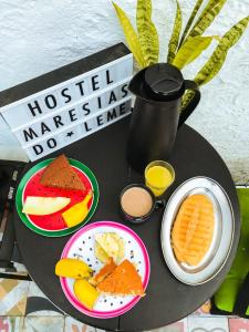 einen Tisch mit Teller mit Speisen und einer Kaffeekanne in der Unterkunft Hostel Maresias do Leme in Rio de Janeiro