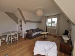 ein Wohnzimmer mit einem Sofa und einem Tisch in der Unterkunft Les Embruns in Bréhal