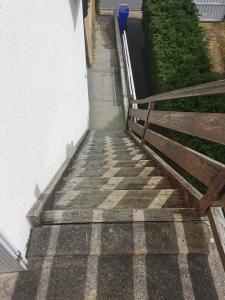 eine Treppe, die zu einem Haus mit einem Holzzaun führt in der Unterkunft Les Embruns in Bréhal