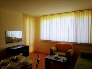 sala de estar con mesa, silla y ventana en Family Apartament Crown Pool&Sea - BastetBS, en Sveti Vlas