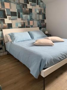 ein großes Bett mit blauer Bettwäsche und Kissen darauf in der Unterkunft Il Sogno nel Cassetto in Turin