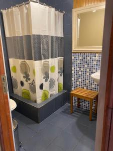 a bathroom with a shower curtain and a sink at Nikos II Adventure in Puerto Natales