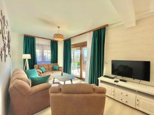 a living room with two couches and a flat screen tv at Villa Serenity Budva in Budva
