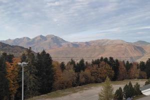 a view of a mountain range with trees and a road at Location appartement à Bonascre in Ax-les-Thermes