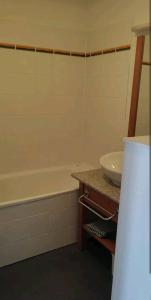 a bathroom with a sink and a bath tub at Location appartement à Bonascre in Ax-les-Thermes