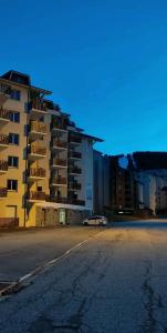 uma rua vazia em frente a um grande edifício em Location appartement à Bonascre em Ax-les-Thermes