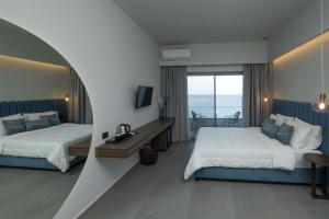 a bedroom with two beds and a view of the ocean at Mochlos Blue in Mochlos