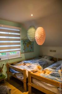 1 dormitorio con 1 cama y 2 linternas de papel en Le Petit Chalet avec hottub., en Sint-Gillis-Waas