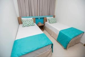 a bedroom with two beds with blue and white at Ilhas do Lago Eco Resort in Caldas Novas