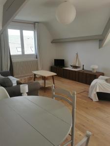 ein Wohnzimmer mit einem Sofa und einem Tisch in der Unterkunft Les Embruns in Bréhal