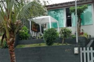 una casa con una palmera y un paraguas blanco en Casa em Camboinhas, Niterói, RJ, en Niterói