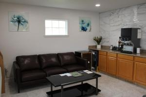 a living room with a couch and a kitchen at Scottish Inns Ashland in Ashland