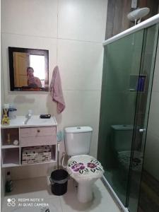 a bathroom with a toilet and a sink and a mirror at Casa em Camboinhas, Niterói, RJ in Niterói