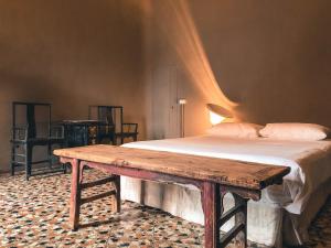 a bedroom with a bed and a wooden table at Palazzo del Settecento in Ravenna