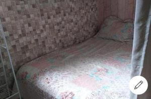 Casa em Camboinhas, Niterói, RJ في نيتيروي: سرير صغير في غرفة صغيرة مع ستارة