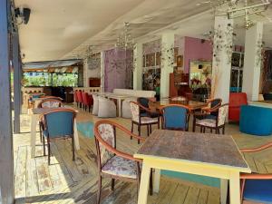 a restaurant with tables and chairs in a room at Family Apartament Crown Pool&Sea - BastetBS in Sveti Vlas