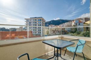 a balcony with a table and chairs and a view at Ivanovic residences in Budva