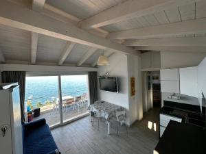 una cucina con soggiorno e vista sull'oceano di La dolce vita , fronte mare a Castelsardo