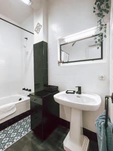 Baño blanco con lavabo y espejo en El Segon Pis, en Berga