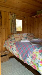 a bedroom with a bed in a wooden cabin at Willowdene shepherds hut in Oswestry