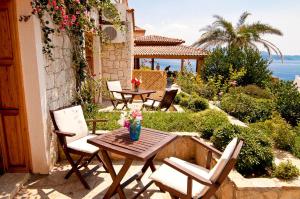 a patio with chairs and a table with a vase of flowers at Lycia Hotel in Kaş