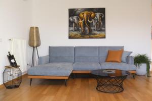 a living room with a couch and a painting of elephants at Luxus Penthouse mit Terrasse, Garage, Fahrradraum und Infrarotsauna in Merano