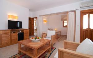 a living room with a table and a television at Lycia Hotel in Kaş