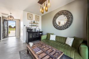 a living room with a green couch and a mirror at Domaine Chardonnay in Temecula