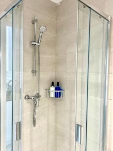 eine Dusche mit Glastür im Badezimmer in der Unterkunft Menorca Chic Apartment Near Beach & Harbour in Cala'n Bosch