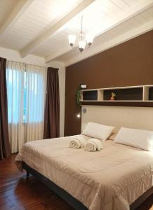 1 dormitorio con 1 cama grande y toallas. en El Cardon - p/6 pax -2 dorm - Amplio y moderno en Salta