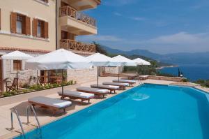 a swimming pool with chairs and umbrellas next to a building at Lycia Hotel in Kaş